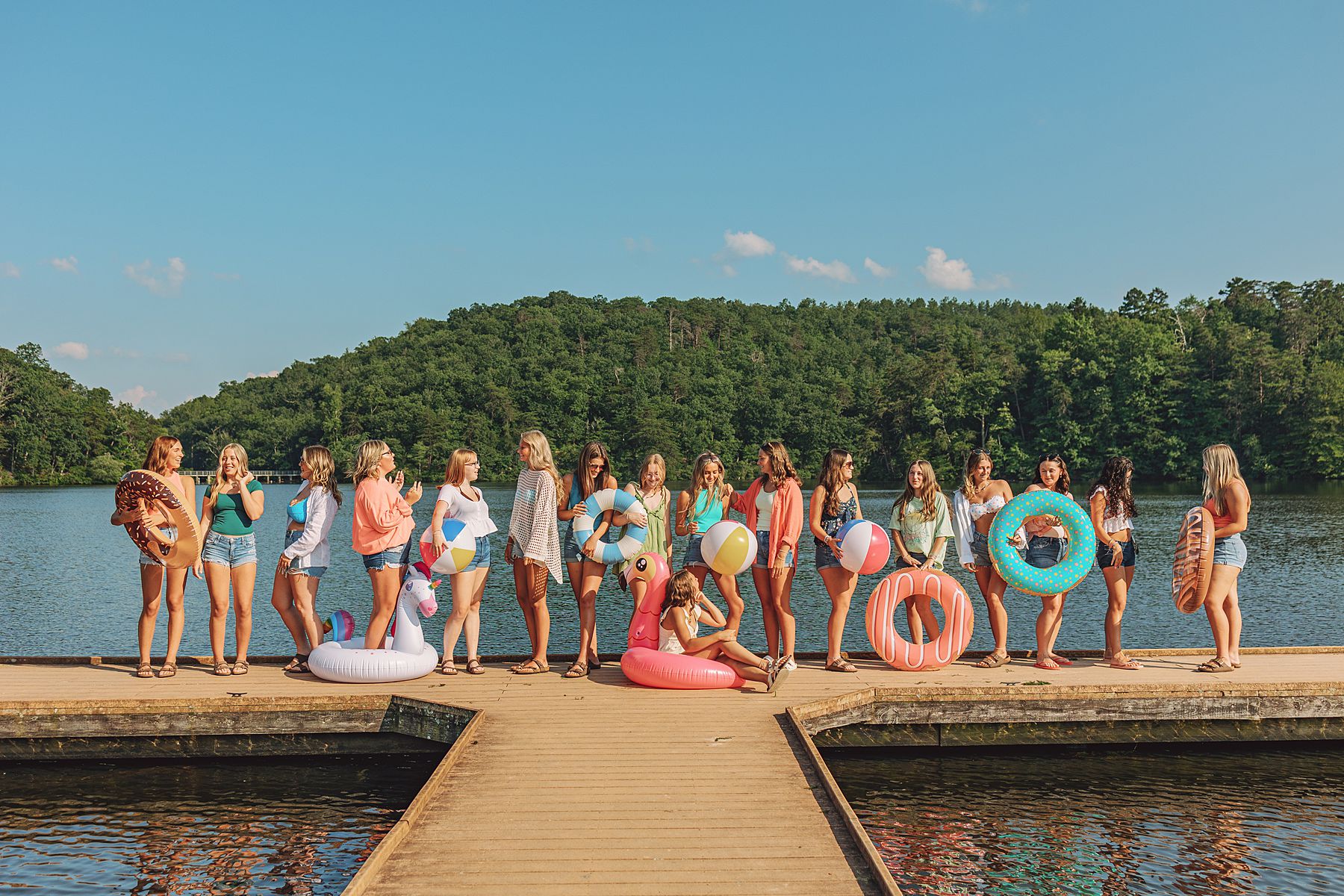 Group of high school seniors on bright floats during summer lake session